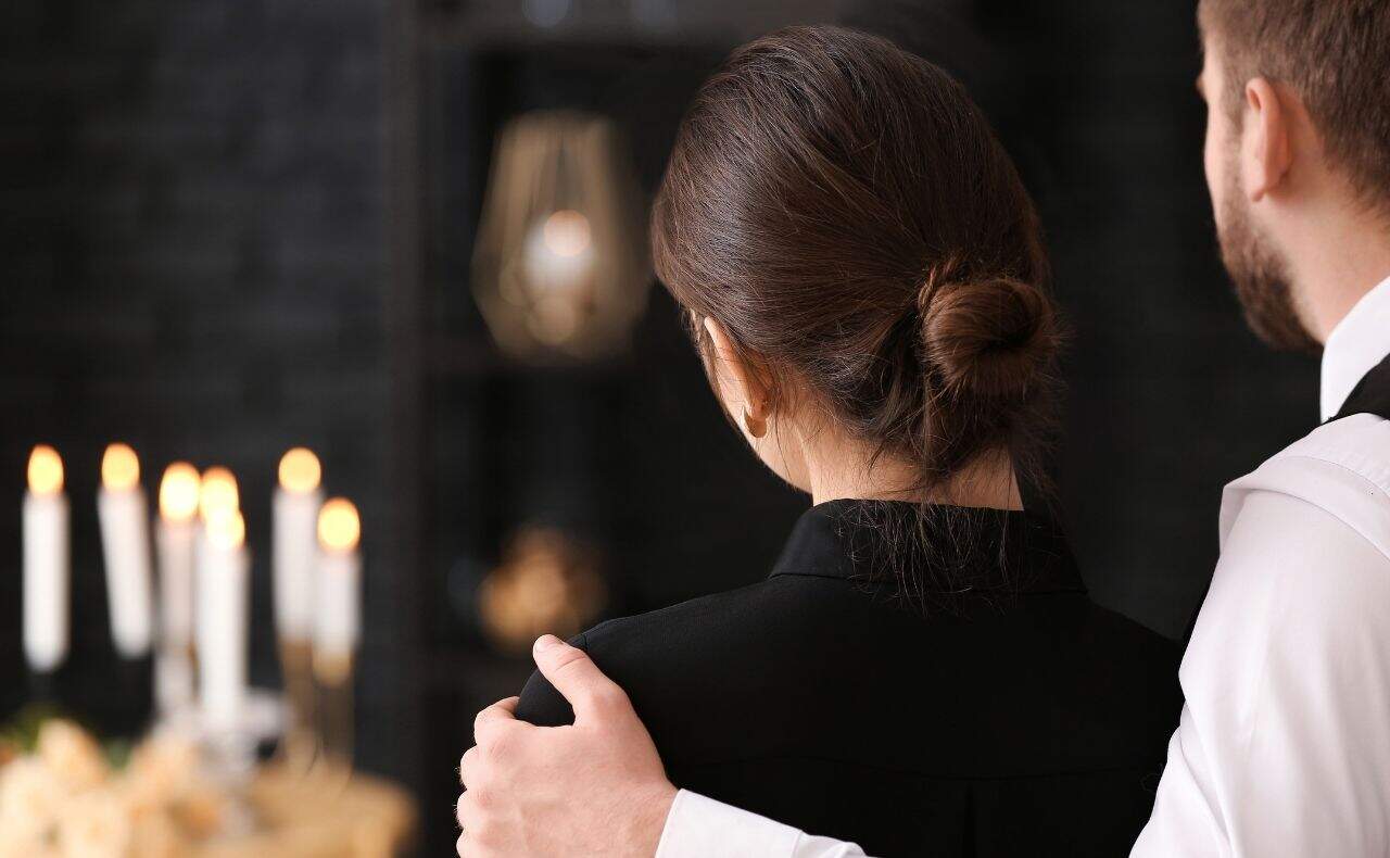 Remerciements après enterrement : un homme réconfortant une femme après un enterrement.